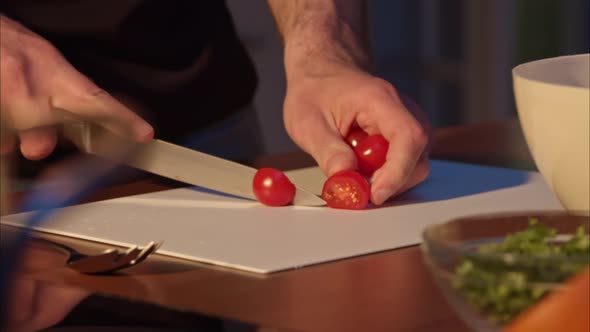 Male Hands Cut Cherry Tomato