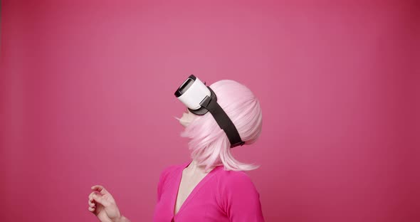 Woman Uses a Virtual Reality Glasses on Isolated Pink Background alt