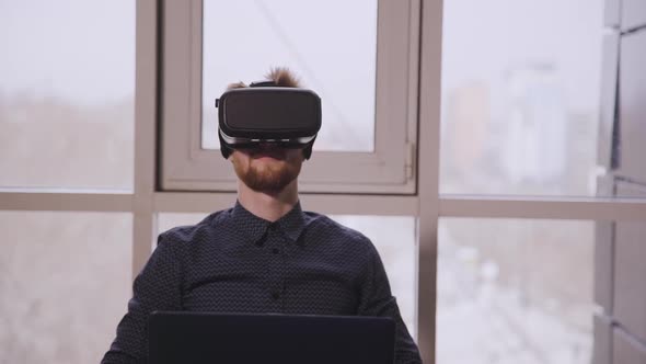 White Man Testing VR Simulator in Game Development Office.