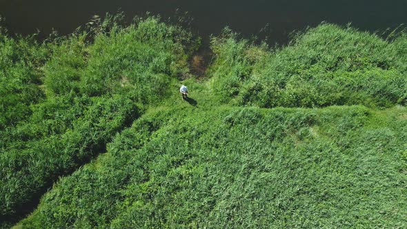 A Fisherman On The Shore Of The Lake Catches Fish On A Spinning Rod. Aerial Photography alt