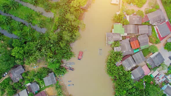 An aerial view over a fishing village by a canal in the countryside alt