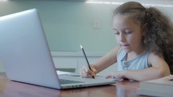 Little Girl a Cute Elementary School Child of 7-8 Years Old at Home Studying in Family Learning alt