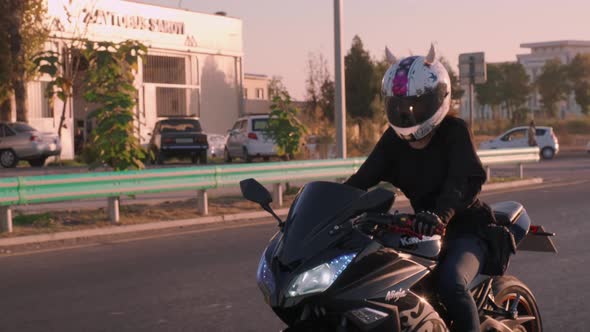 Woman With The Helmet With The Horns Is Driving Down The Road