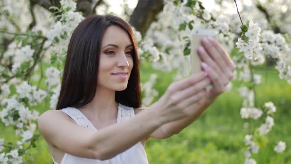 Girl near a blooming apple tree alt
