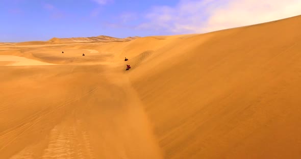 Adults Against a Backdrop of Massive Red Dunes alt