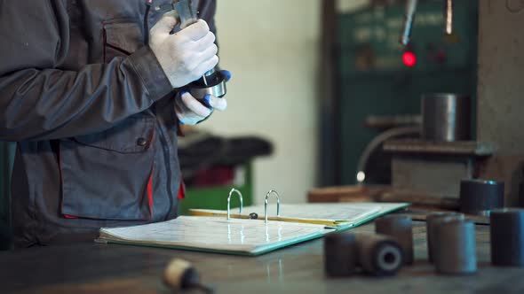 Factory Worker Measuring Detail. Man measuring part with callipers in workshop alt