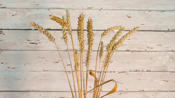 Wheat Spikelets Are Spinning On The Turntable Against The Background Of Old Wood. alt