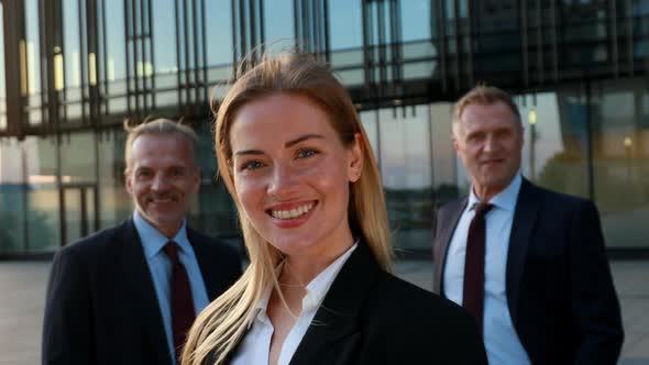 Business Team. Leader Woman in Front and the Team in Background. Business Building Exterior