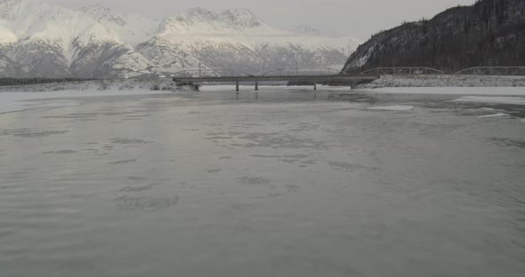 Aerial helicopter wide shot, tracking high above small blue and white airplane flying over bay and t