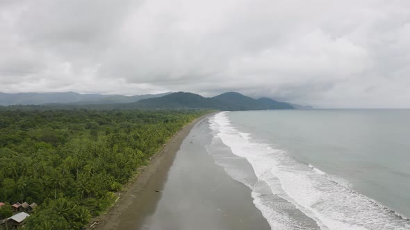 Aerial shot of a blacksand beach during a cloudy day on the Pacific Coast, Colombia. alt
