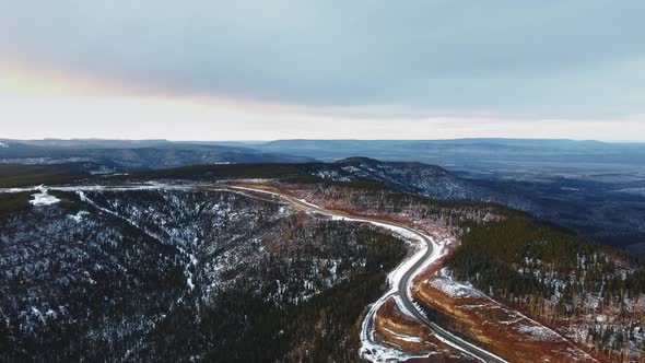 Drone camera shoots the road at the top of a mountain covered with snow in Alberta, Canada alt