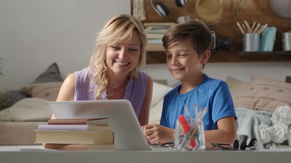 Happy family at home, smiling mother with son use computer