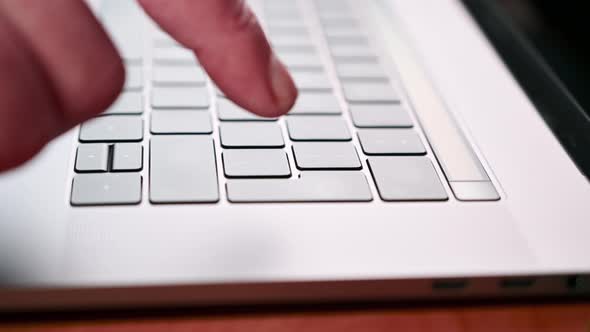 a man's hand multiple times presses the enter button on a laptop. Work at home or in office.