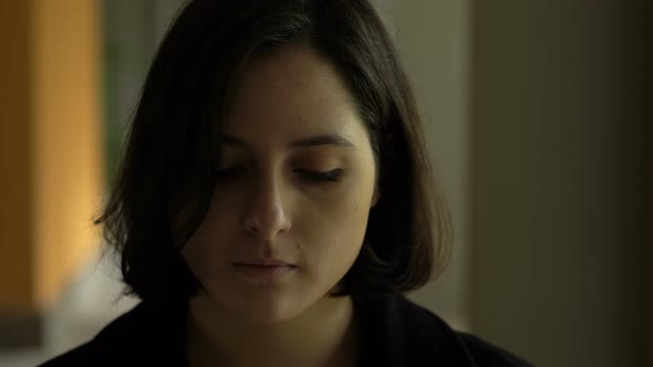 thoufghtful serious pretty young woman looking at acmera in the dark- outdoor alt