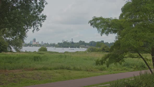 Rotterdam skyline seen from Kralingse Bos in the Netherlands with a bicycle path in the foreground alt
