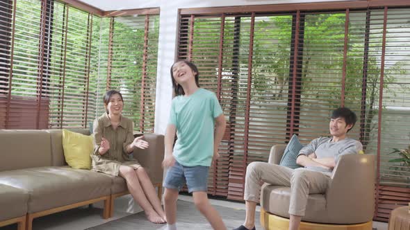 asian family dad mom and son funny dancing in living room at home