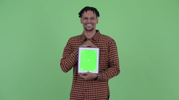 Happy Young Handsome African Man Talking While Showing Digital Tablet alt