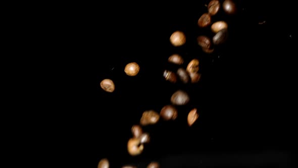 Roasted Coffee Beans Falling Down Slow Motion Isolated on Black Backdrop