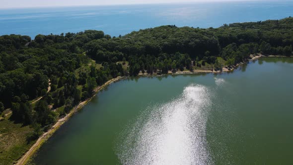 Rising and panning to show Lake Michigan over the lake at Dune Harbor. alt