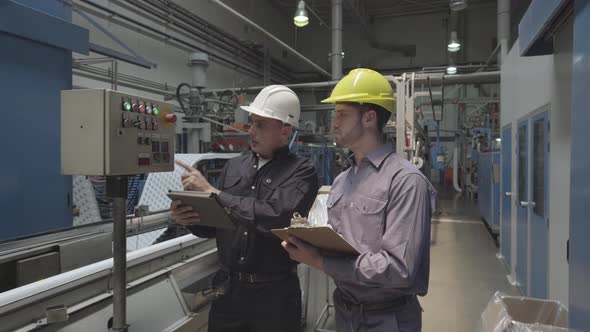 Engineers examining control panel in factory