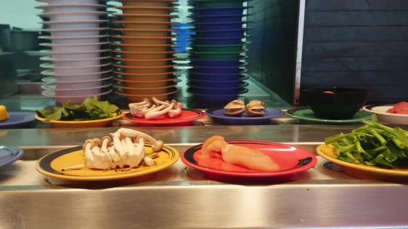 Japanese food belt. Conveyor shabushabu belt. Row of japanese food buffet dishes in belt.