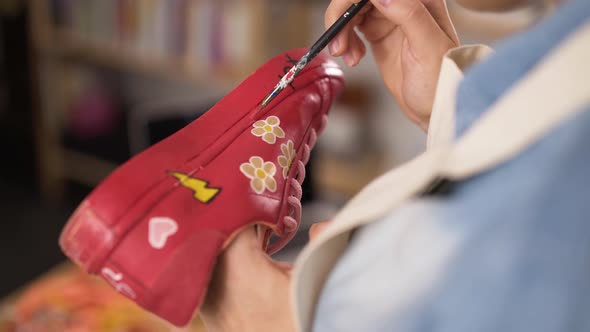 Young Artist Customizing Sneakers with Funky Design and Paint alt