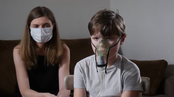 Mother in Mask and Her Sick Child Using Nebulizer During COVID-19 Pandemic