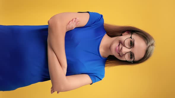 VERTICAL VIDEO POV Blonde Woman in Blue t Shirt Posing with Crossed Hands Isolated on Orange Studio alt
