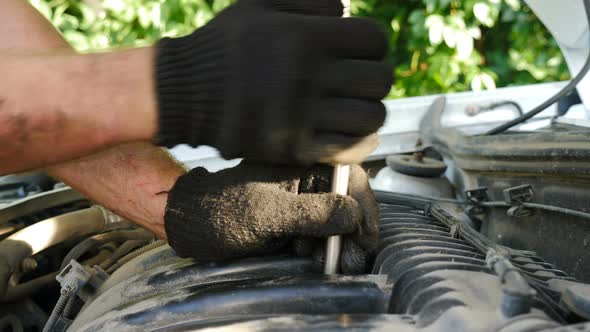 Auto Mechanics in Gloves Repairing Car at Service Station alt