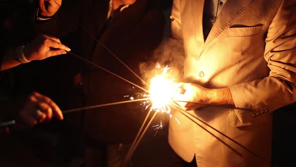 people light sparklers at a party in the evening