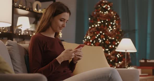 Woman chatting with her smartphone at Christmas