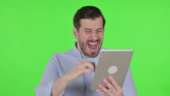Portrait of Man Having Loss on Tablet in Office Green Screen alt