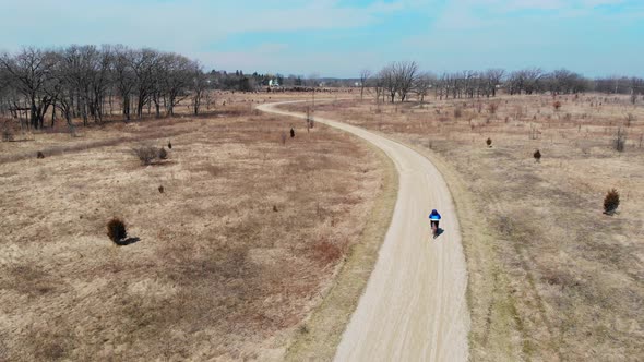 Aerial Top View Man Who Rides a Bicycle in an Illinois State Park. Bike Ride in the Park. The Drone alt