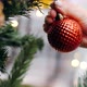 Girl decorates the Christmas tree. Close-up, hand, red Christmas ball - VideoHive Item for Sale