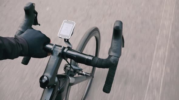 Cycling man holding handlebar in cycling gloves with computer showing speed power cadence telemetry alt