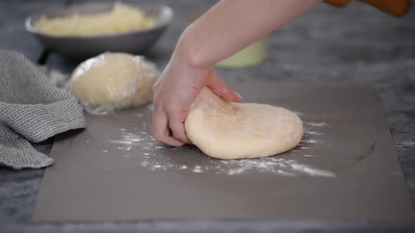 Female Hands Cook Roll Out the Dough for Khachapuri Rolling Pin on a Wooden Table Sprinkled with