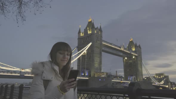 Tourist woman walking on Tower Bridge in London, England