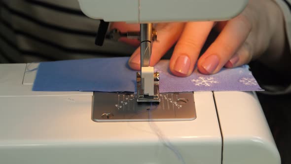Seamstress sews on a sewing machine alt