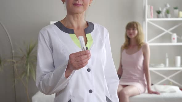 Unrecognizable Caucasian Doctor Showing Needles for Acupuncture at Camera As Blurred Blond Woman alt