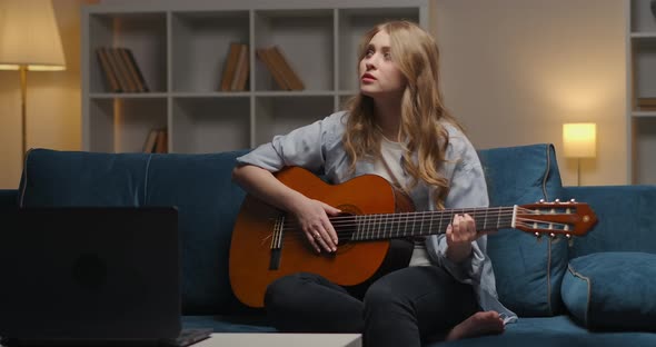 Evening Home Entertainment During Selfisolation and Lockdown Woman Is Playing Music on Guitar Medium alt