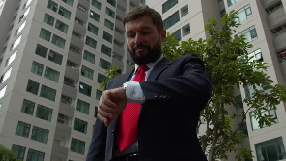 Successful Middleaged Businessman in Luxurious Clothes in the City Center is Waiting for a Business alt