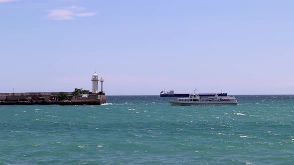 the Ship is Moving Against the Background of the Yalta Crimea Lighthouse