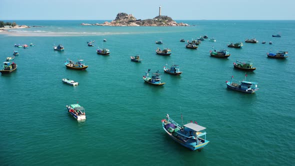 Boats on Binh thuan coast, Ke Ga Lighthouse in background. Aerial circling alt