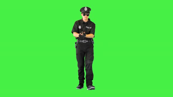 Young Policeman Walks Gets the Gun Out and Takes an Aim on a Green Screen Chroma Key
