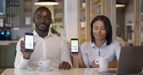 Portrait of Business Colleagues in Restaurant Showing Vaccinated Qrcode on Smartphone at Camera alt