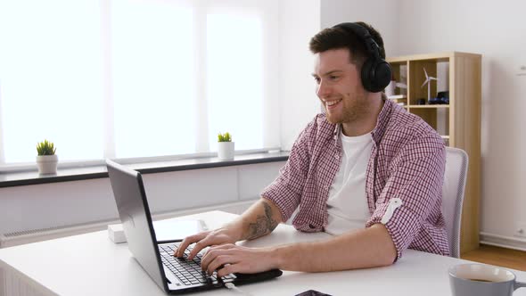 Happy Man in Headphones with Laptop at Office 49 alt