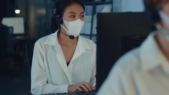 Asia young call center team or customer support service executive wearing face mask prevent .