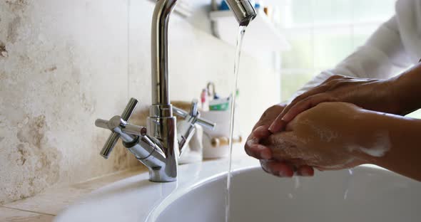 Grandmother helping her granddaughter to wash hands in bathroom 4k alt