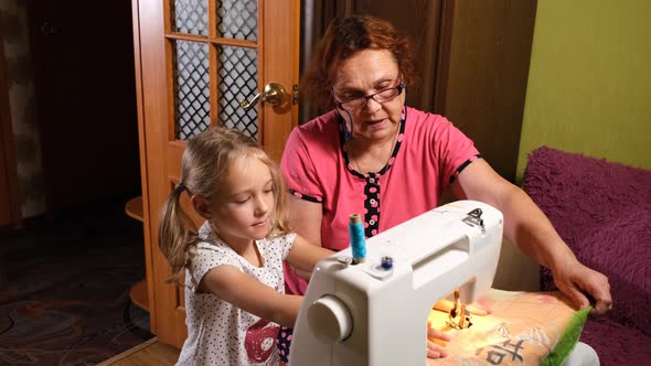 Girl with Grandma Using Sewing Machine Together alt