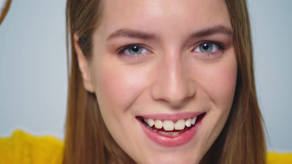 Closeup Smiling Woman Having Fun with Donuts at Camera on Grey Background alt